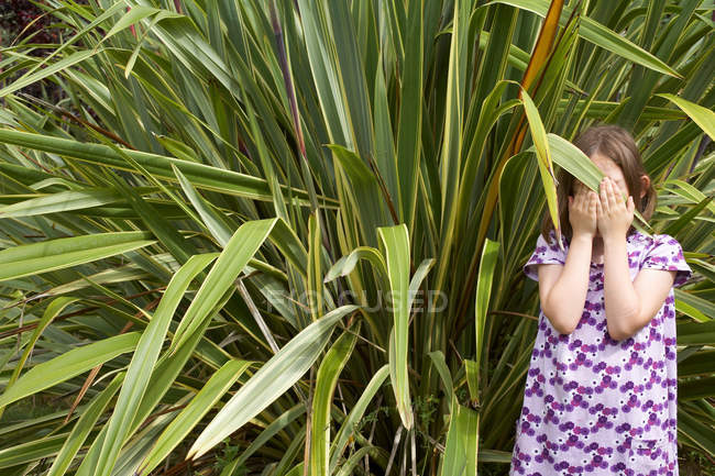 Молодая девушка прячет лицо травяными левами — стоковое фото