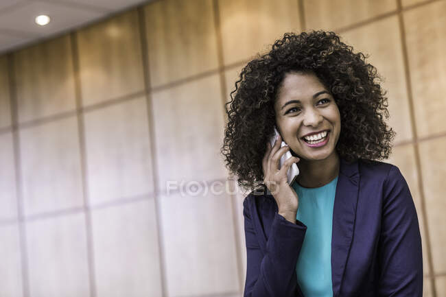 Junge Geschäftsfrau spricht im Büro mit Smartphone — Stockfoto