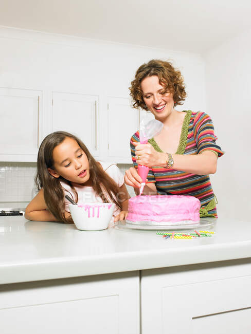 Mère et fille glaçage gâteau — Photo de stock