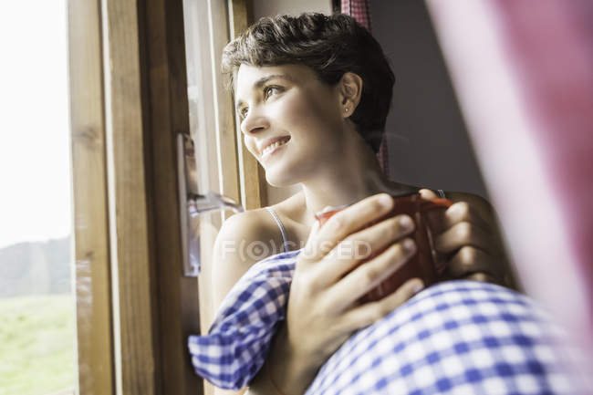 Jovem mulher bebendo café em chalé de férias — Fotografia de Stock