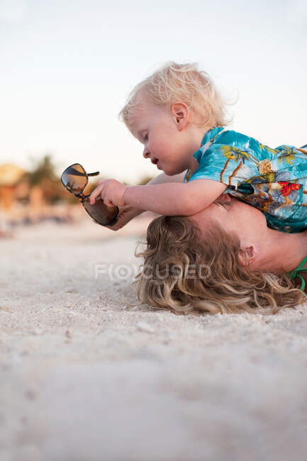 Mère et tout-petit fils jouant sur la plage — Photo de stock