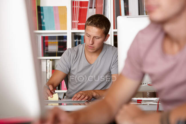 Les jeunes hommes travaillent, se concentrent sur les antécédents — Photo de stock