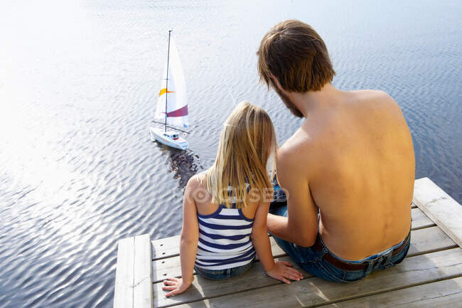 Padre e figlia su un molo, a giocare — Foto stock