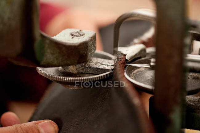 Close up of person using machine to work leather — Stock Photo
