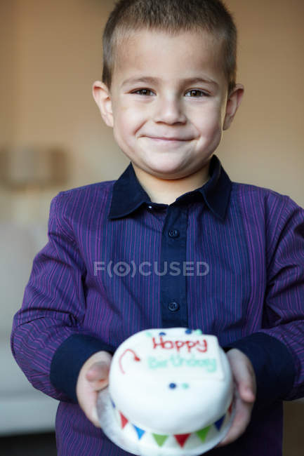 Garçon tenant gâteau miniature, mise au point sélective — Photo de stock