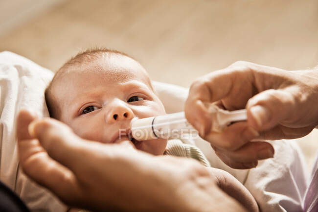 Bebê para alimentação dos pais com seringa — Fotografia de Stock