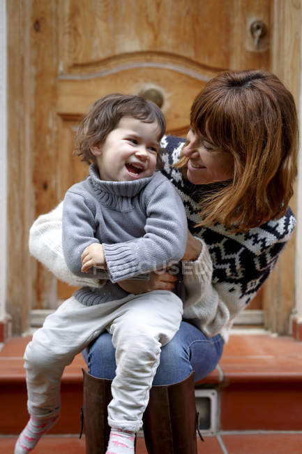 Mother and daughter on doorstep laughing — Stock Photo