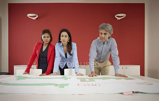 Three architects with blueprints — Stock Photo