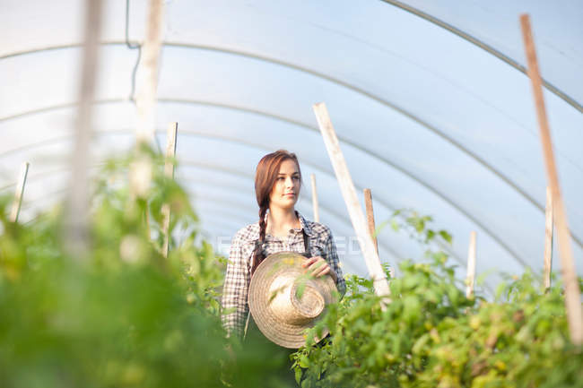 Junge Frau im Gemüsegewächshaus — Stockfoto
