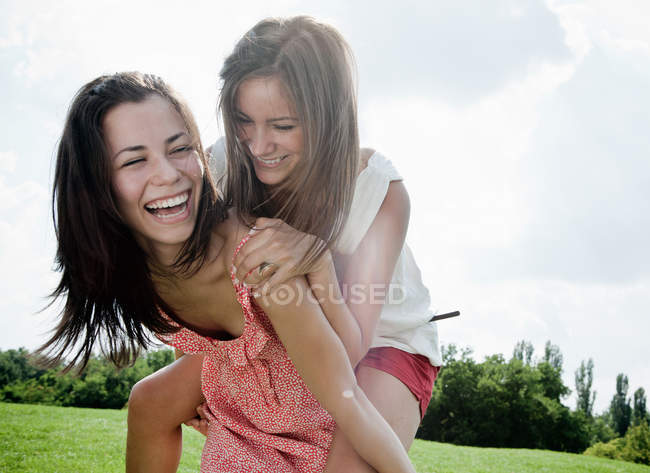 Mulheres sorridentes brincando ao ar livre juntas — Fotografia de Stock