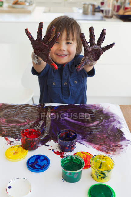 Boy finger painting on paper — Stock Photo