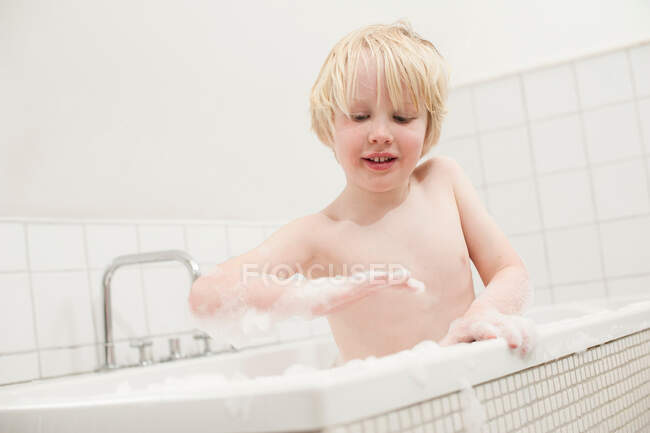 Мальчик смотрит на мыло в ванной — стоковое фото