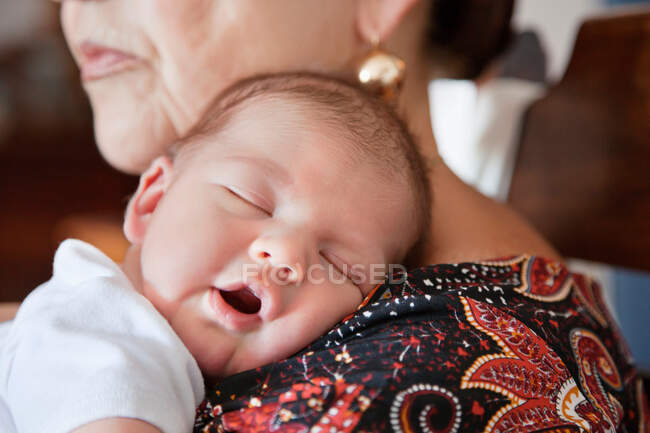Дитина спить на плечах бабусь — стокове фото