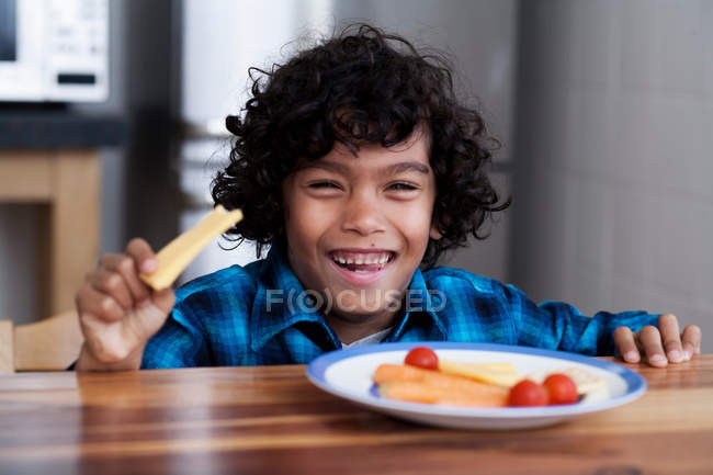 Porträt eines lächelnden Jungen, der Snacks isst — Stockfoto