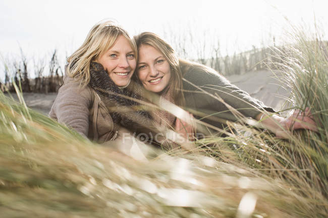 Mujeres sonrientes relajándose en la playa - foto de stock