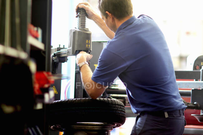 Mechanic repairing wheel in workshop — Stock Photo