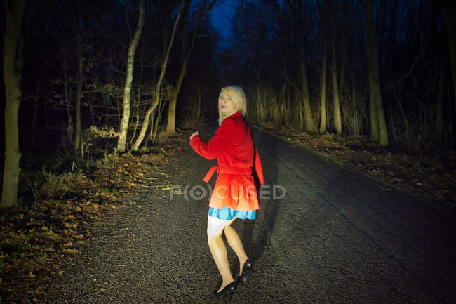 Donna che corre nella paura nei boschi di notte — Foto stock