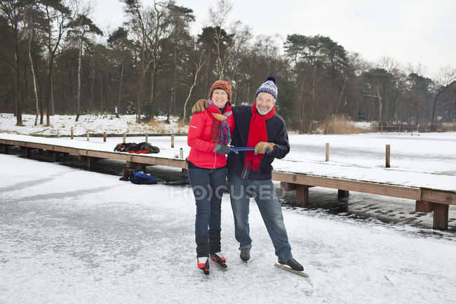 Couple ice skating, holding hands — Stock Photo