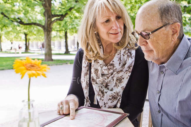 Menu de lecture pour les couples plus âgés au café — Photo de stock