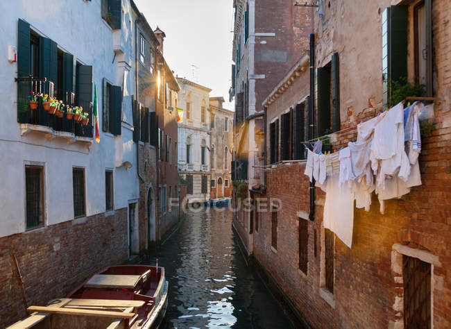 Edificios y botes de remos en el canal urbano - foto de stock