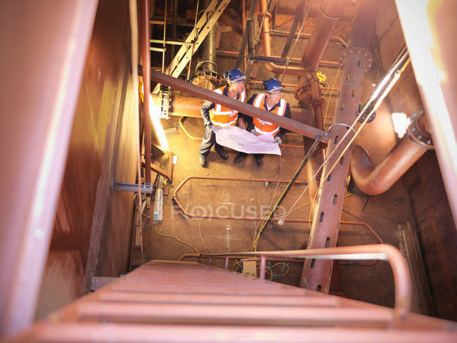 Vista en ángulo alto de ingenieros que inspeccionan la nave - foto de stock