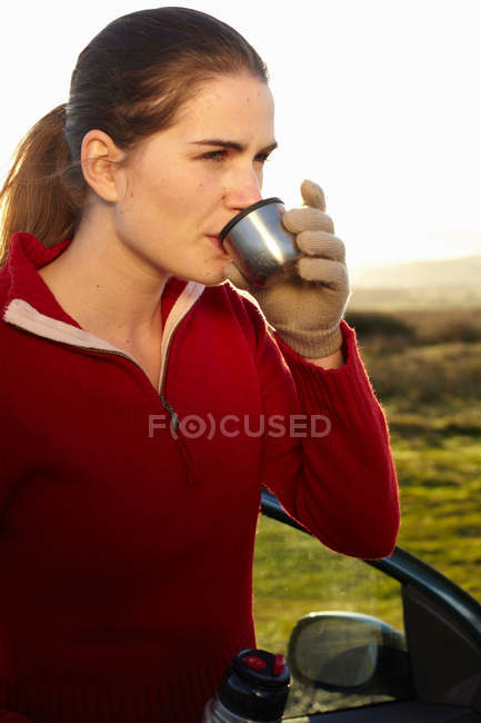 Mulher bebendo café de garrafa térmica — Fotografia de Stock