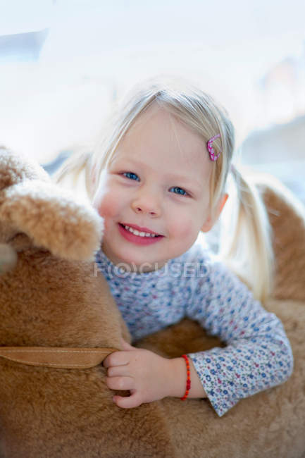 Sorridente ragazza tenendo orsacchiotto — Foto stock