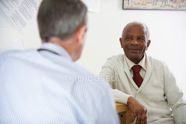Idoso negro falando com médico — Fotografia de Stock