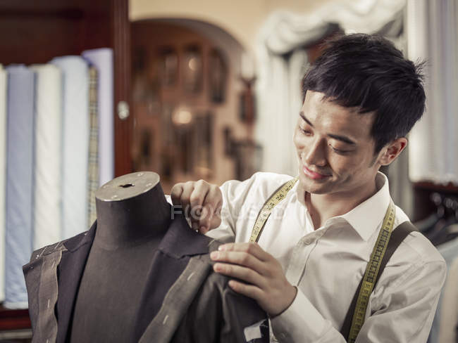 Trainee tailor pinning garment in traditional tailors shop — Stock Photo