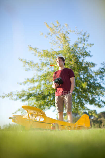 Homem brincando com avião de brinquedo no parque — Fotografia de Stock