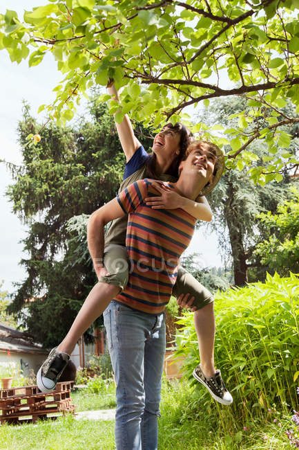 Mann hält Frau in Obstgarten fest — Stockfoto
