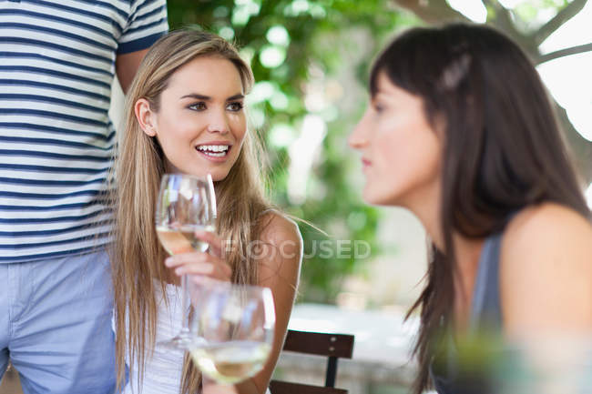 Друзі п'ють вино за столом на відкритому повітрі, вибірковий фокус — стокове фото