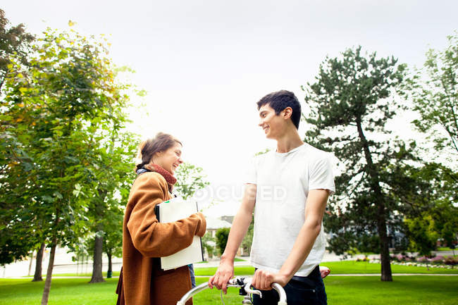 Усміхнена пара розмовляє в парку, вибірковий фокус — стокове фото