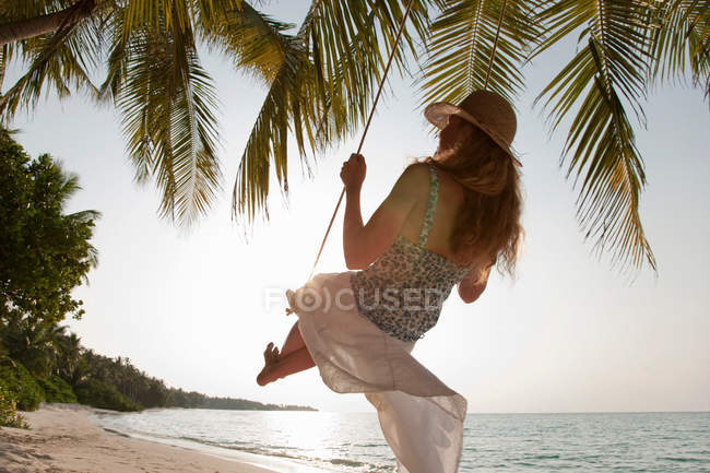 Mulher balançando na praia tropical — Fotografia de Stock