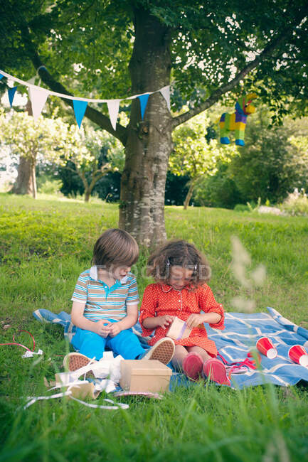 Children giving gifts at birthday picnic — Stock Photo