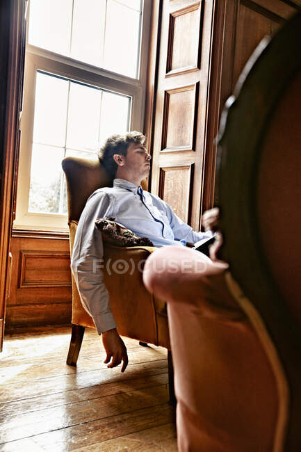 Человек дремлет в кресле — стоковое фото
