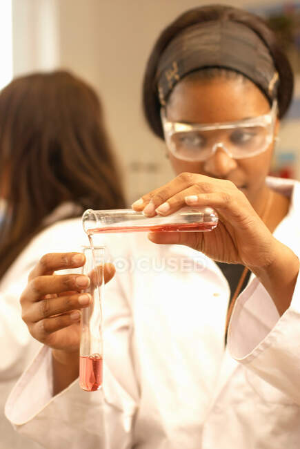 Scientist pouring liquid into test tube — Stock Photo