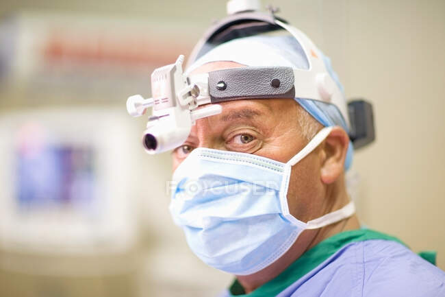 Chirurgien portant masque et lampe frontale — Photo de stock