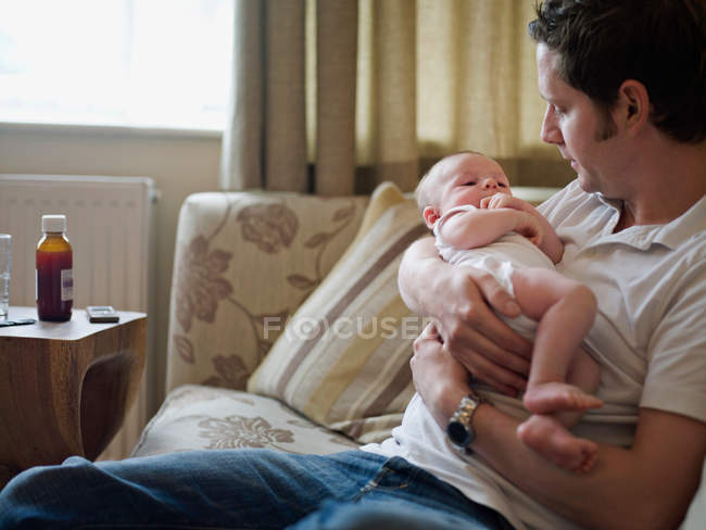 Un padre sosteniendo un bebé recién nacido - foto de stock