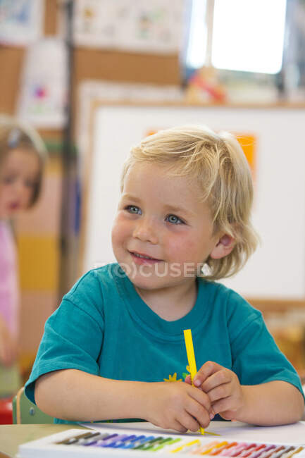 Garçon d'âge préscolaire avec stylo à colorier en classe — Photo de stock