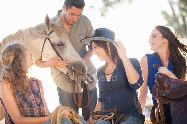 Quatro jovens amigos com cavalo — Fotografia de Stock