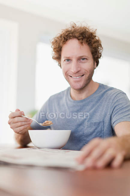 Hombre leyendo el periódico en el desayuno - foto de stock