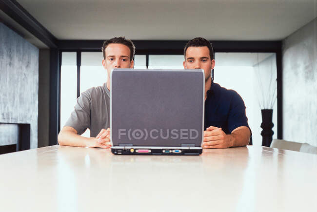 Empresarios usando el ordenador portátil juntos - foto de stock