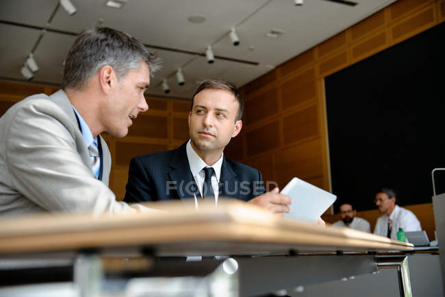 Empresários usando tablet computador na mesa — Fotografia de Stock