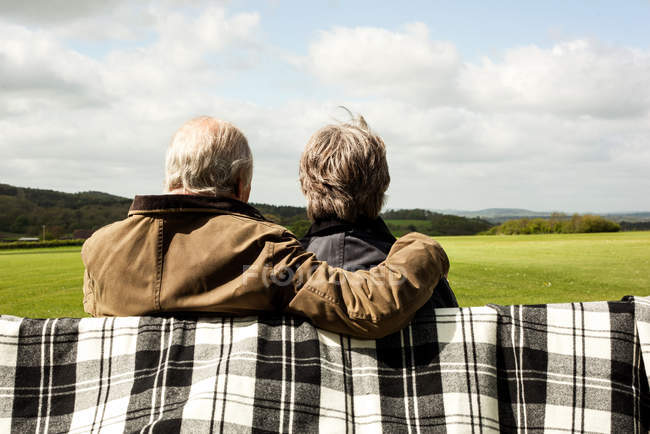 Vue arrière du couple de personnes âgées profitant de paysages sur le terrain — Photo de stock