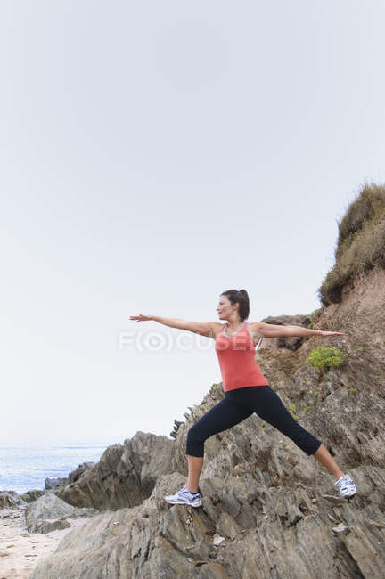 Donna matura che si esercita sulle rocce — Foto stock