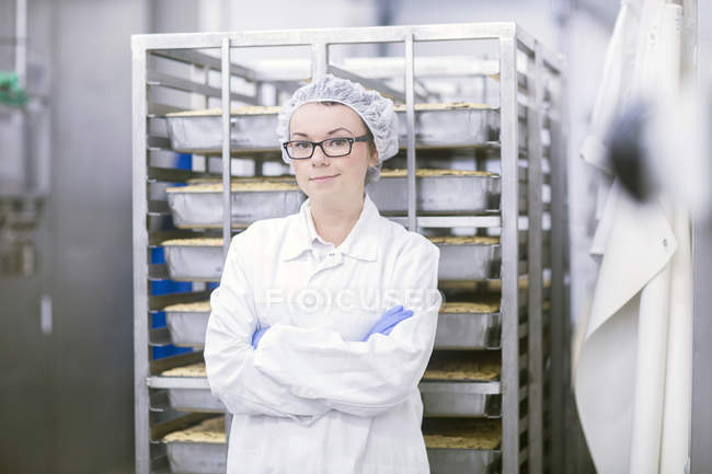 Factory worker wearing overall and hair net looking at camera — Stock Photo