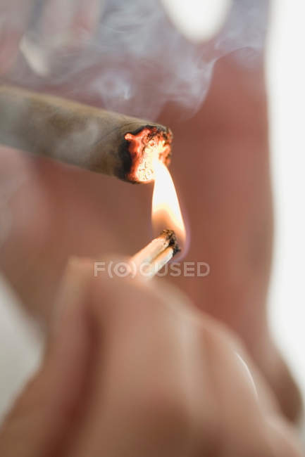Крупным планом женщина закуривает сигарету — стоковое фото