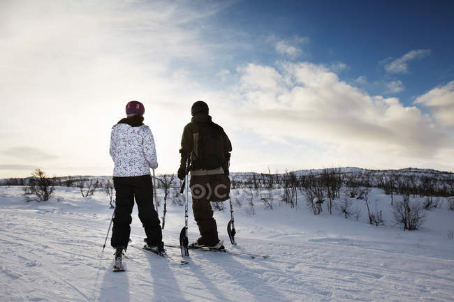 Um esquiador de pernas com namorada, visão traseira — Fotografia de Stock