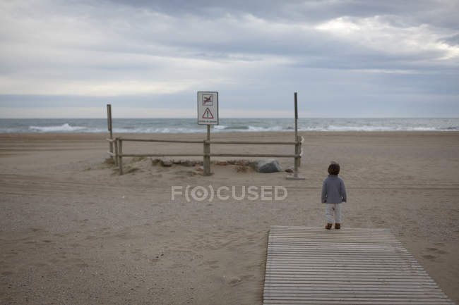 Girl on beach looking away at ocean — Stock Photo